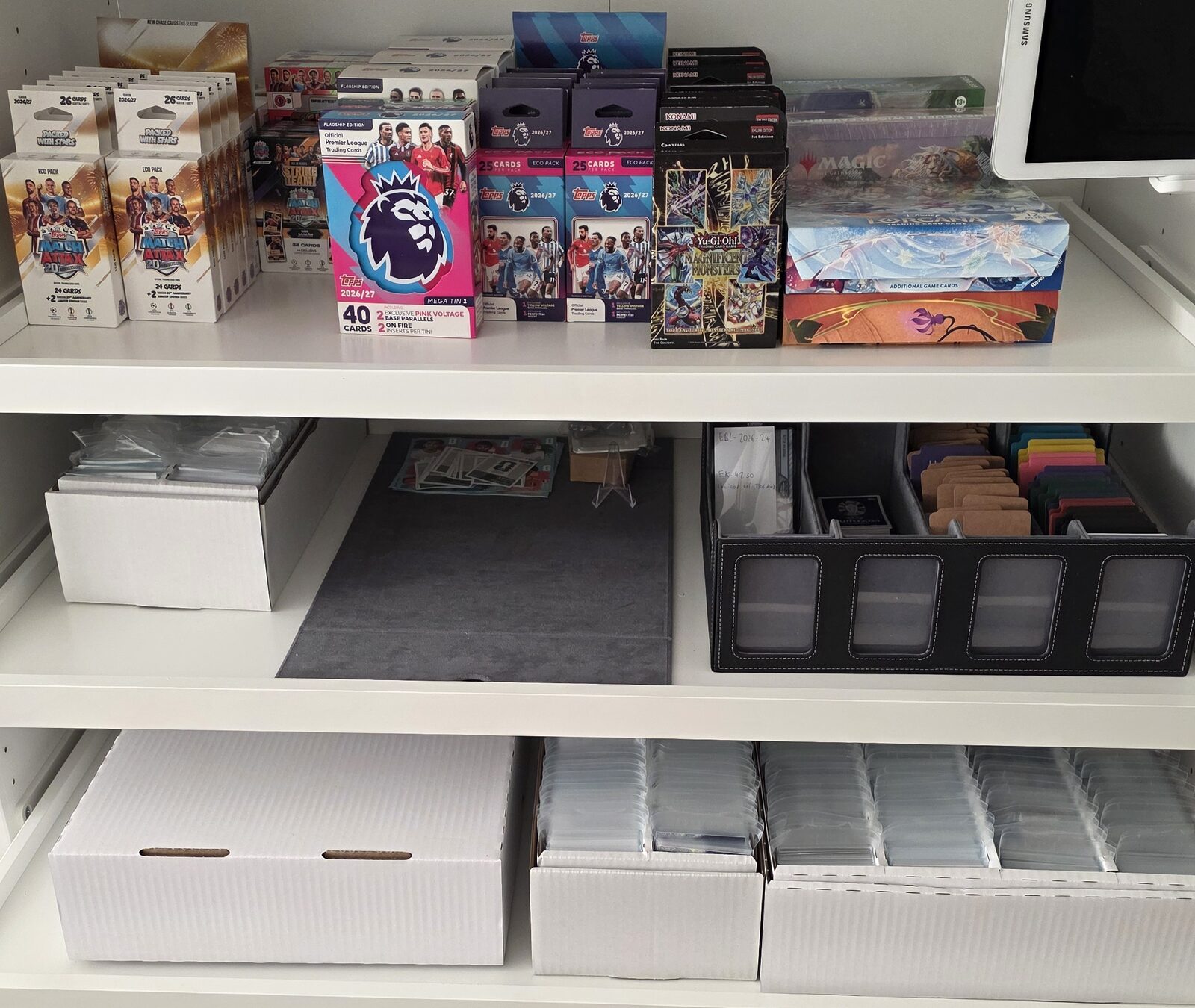 Lagerregal von Sammelgeist mit Sammelkarten-Boxen, Toploadern und versiegelten Produkten